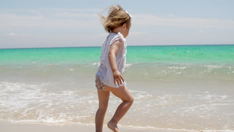 Little-girl-romping-at-the-edge-of-the-surf