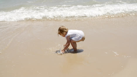 Kleines-Mädchen-Spielt-Im-Meer