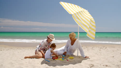 Oma-Und-Kleines-Mädchen-Spielen-Im-Strandsand