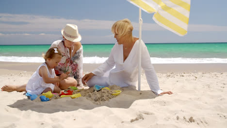 Oma-Und-Kleines-Mädchen-Spielen-Im-Strandsand
