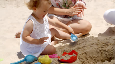 Kleines-Mädchen-Spielt-Mit-Sandspielzeug-Am-Strand