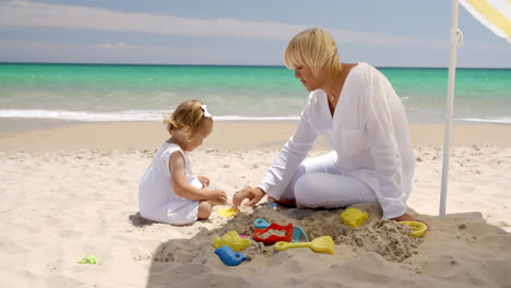 Süßes-Mädchen-Und-Großmutter-Spielen-Am-Strand
