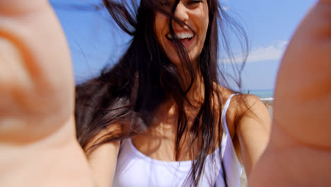 Lächelnde-Frau-Unter-Selbstporträt-Am-Windigen-Strand