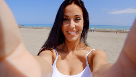 Young-brunette-woman-smiling-while-making-a-selfie