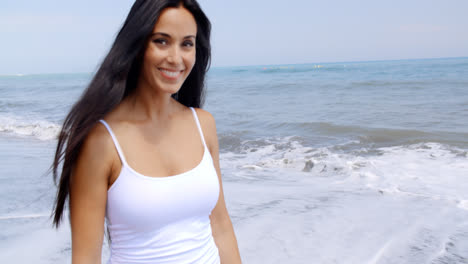 Woman-Walking-on-Beach-and-Smiling-at-Camera