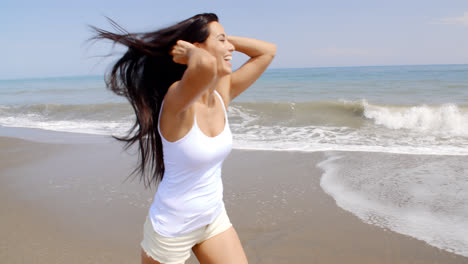 Woman-Walking-on-Windy-Beach-with-Hands-in-Hair