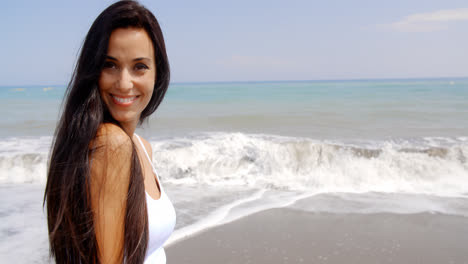 Brunette-Woman-on-Beach-Smiling-Over-Shoulder