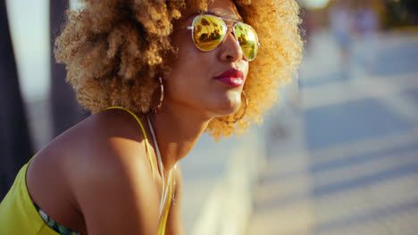 Sensual-Girl-with-Afro-Resting-on-Promenade