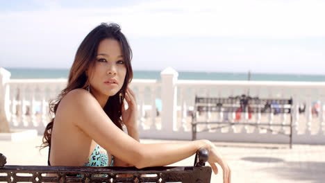 Young-woman-relaxing-on-a-bench-at-the-sea