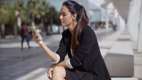Elegant-businesswoman-checking-her-phone-messages