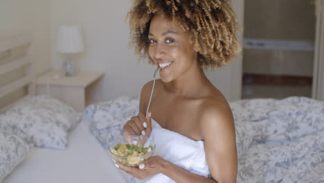 Young-Woman-On-Bed-Eating-Vegetable-Salad