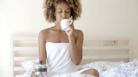 Attractive-Woman-With-A-Cup-Of-Coffee-On-The-Bed