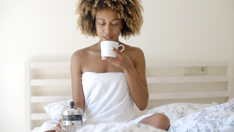 Attractive-Woman-With-A-Cup-Of-Coffee-On-The-Bed