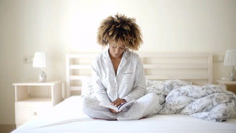 Woman-Reading-A-Book-On-Bed