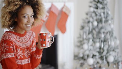 Smiling-woman-drinking-a-mug-of-Christmas-coffee
