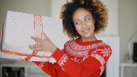 Beautiful-Girl-Shaking-Her-Christmas-Boxed-Gift