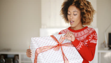Pretty-Young-Woman-Opening-Christmas-Gift