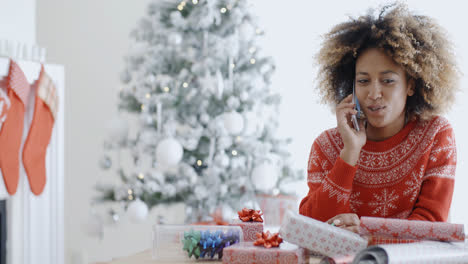 Young-African-woman-wrapping-gifts-at-Christmas