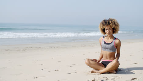 Woman-Sitting-On-The-Beach-In-Lotus-Pose