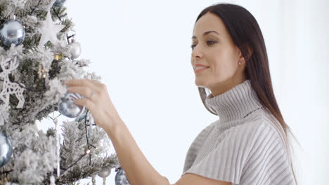 Stylish-woman-admiring-a-Christmas-tree