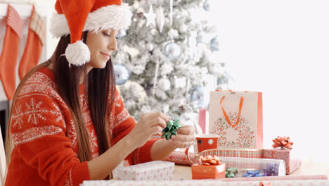 Young-woman-sitting-wrapping-Christmas-gifts