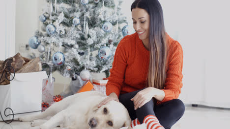 Laughing-young-woman-with-her-dog-at-Christmas