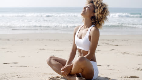 Woman-Meditating-On-Beach-In-Lotus-Position