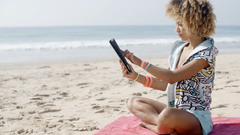 Woman-Uses-Touchpad-Tablet-On-The-Beach