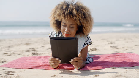 Woman-Uses-A-Tablet-On-The-Beach