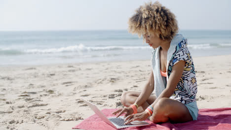 Girl-Working-With-Laptop-On-The-Sand-Beach