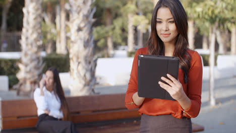 Young-businesswoman-using-a-tablet-outdoors