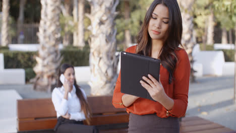 Young-businesswoman-using-a-tablet-outdoors