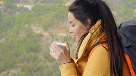 Young-woman-backpacker-savoring-her-coffee