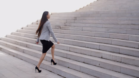Serious-woman-walking-up-staircase