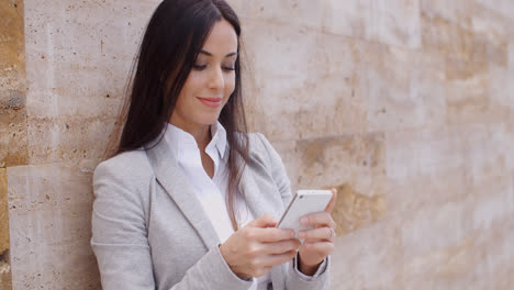 Female-worker-texting-and-leaning-against-wall