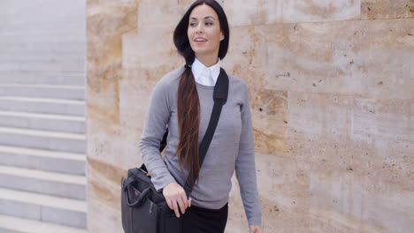 Gorgeous-business-woman-walking-past-wall