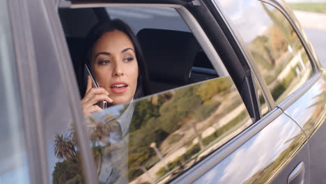 Curious-business-woman-on-phone-looking-from-car