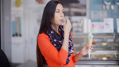 Smiling-young-woman-savoring-an-ice-cream-cone