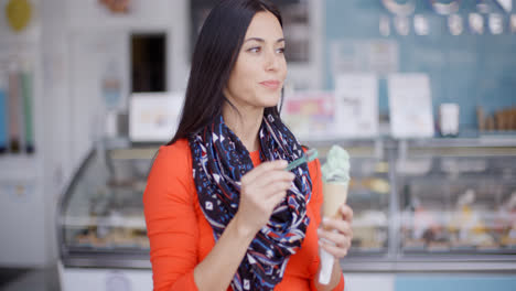 Smiling-young-woman-savoring-an-ice-cream-cone