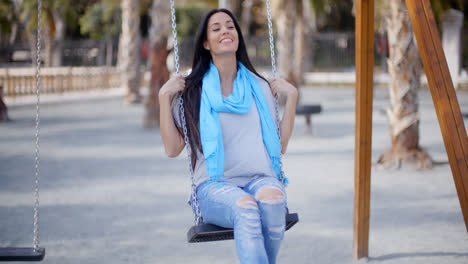 Happy-young-woman-relaxing-on-a-swing