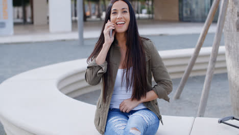 Young-woman-laughing-as-she-chats-on-a-mobile