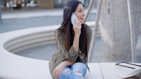 Young-woman-laughing-as-she-chats-on-a-mobile