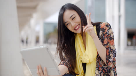 Cheerful-female-gesturing-for-tablet-camera