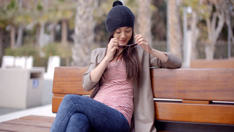 Trendy-young-woman-relaxing-on-a-park-bench