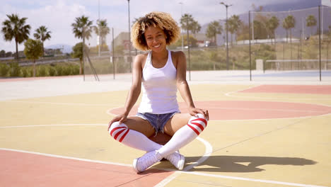 Pretty-young-female-athlete-sits-on-basketball