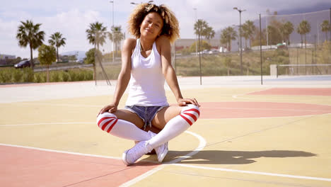 Pretty-young-female-athlete-sits-on-basketball