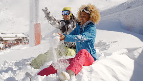 Young-couple-playing-in-the-snow-at-a-ski-resort