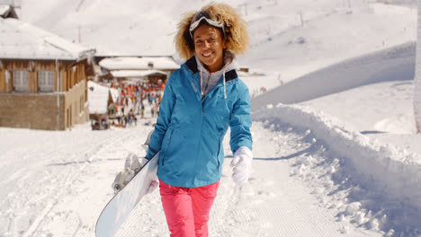 Sonriente-Mujer-Joven-Y-Bonita-Llevando-Una-Tabla-De-Snowboard