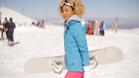 Trendy-young-woman-carrying-her-snowboard