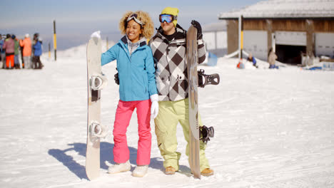 Happy-young-couple-posing-with-their-snowboards